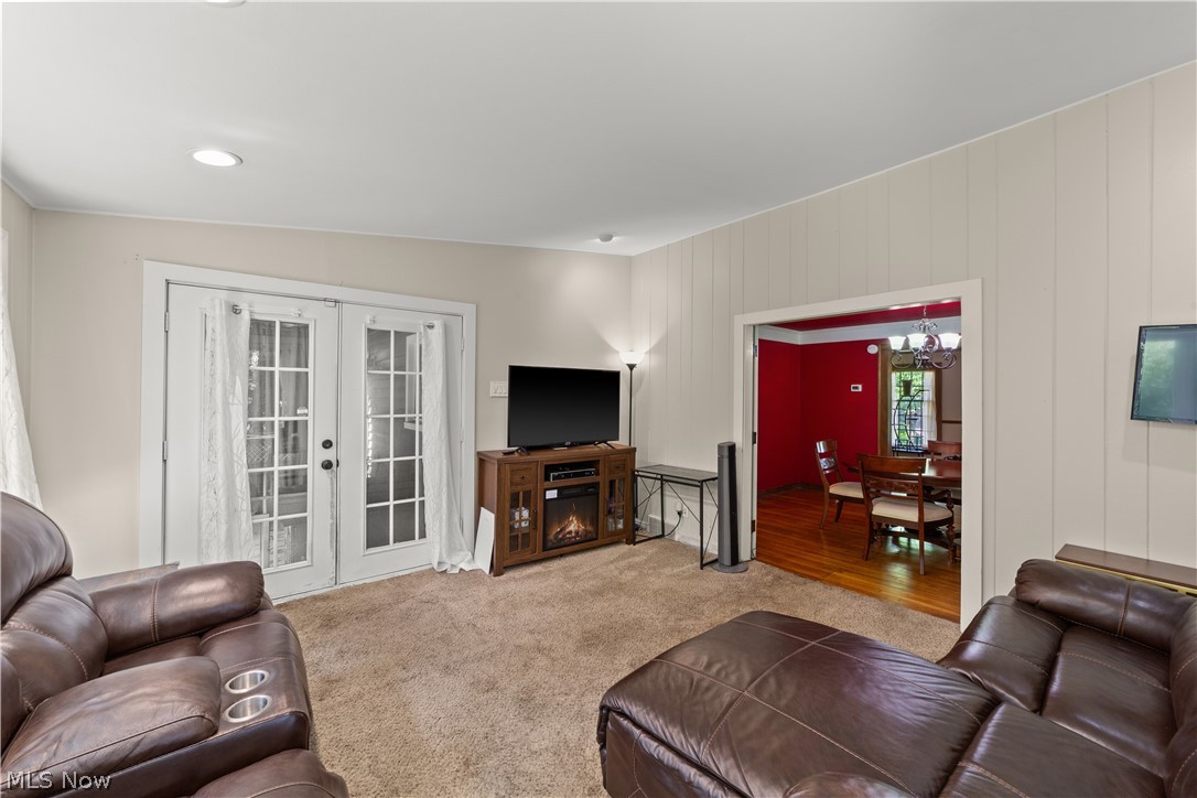 1237 Yellowstone Road Cleveland, OH 44121 - Photo 18 of 48 Living room featuring a notable chandelier, lofted ceiling, french doors, and light carpet