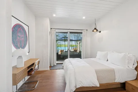 a bedroom with a bed and dresser with mirror