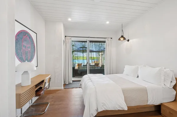 a bedroom with a bed and dresser with mirror