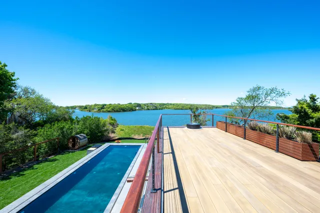 a view of a balcony with wooden floor and fence