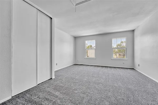 an empty room with windows and closet