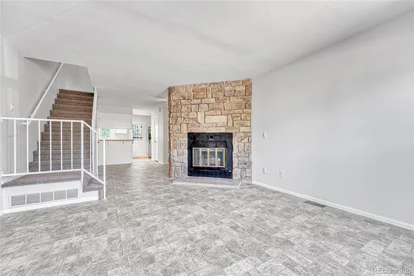 an empty room with fireplace and a window