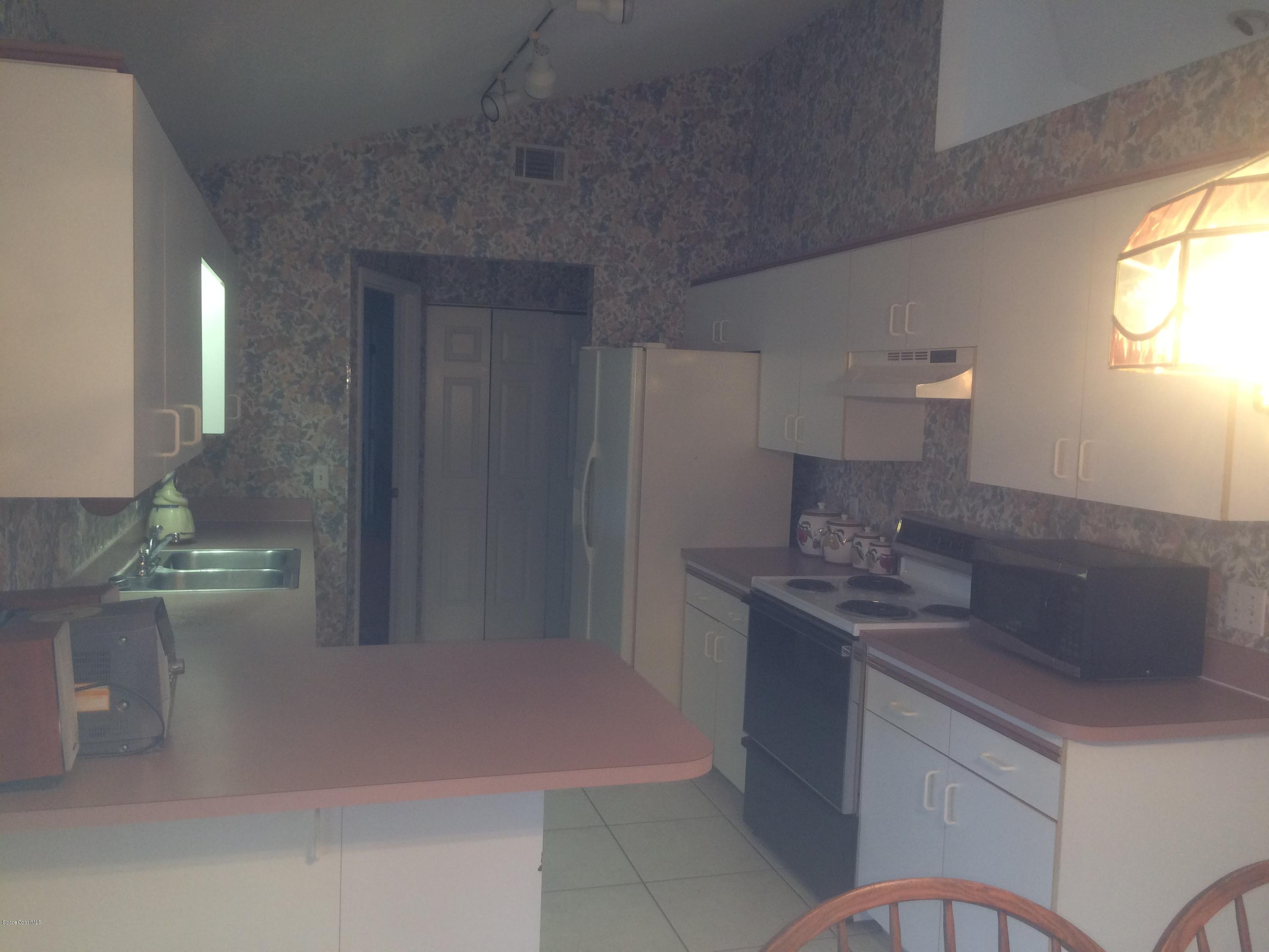 4671 Alfred Street Cocoa, FL 32927 - Photo 5 of 19 a kitchen with stainless steel appliances granite countertop a sink and a refrigerator