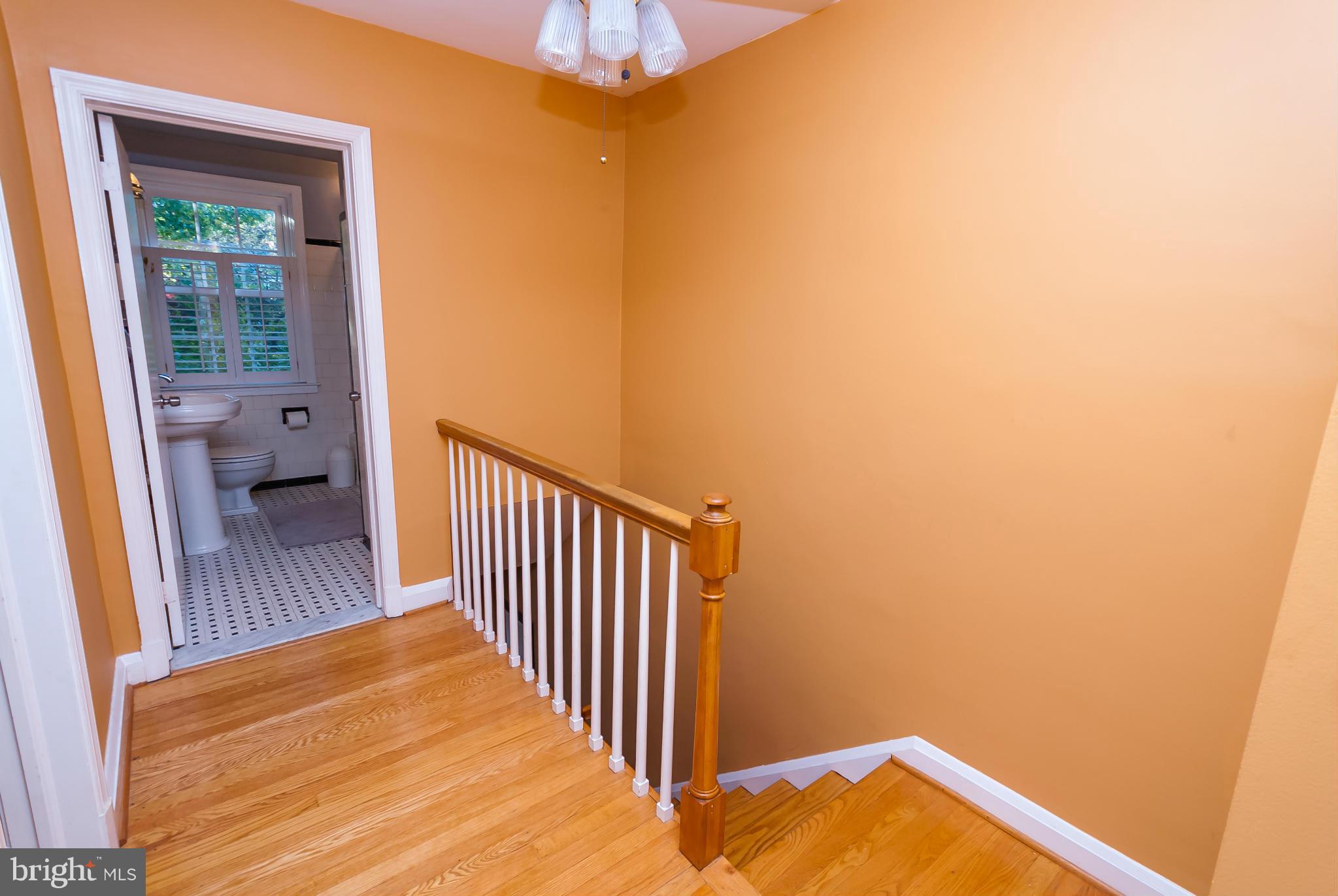 7045 Heathfield Road Baltimore, MD 21212 - Photo 12 of 27 a view of a hallway with wooden floor and a bathroom