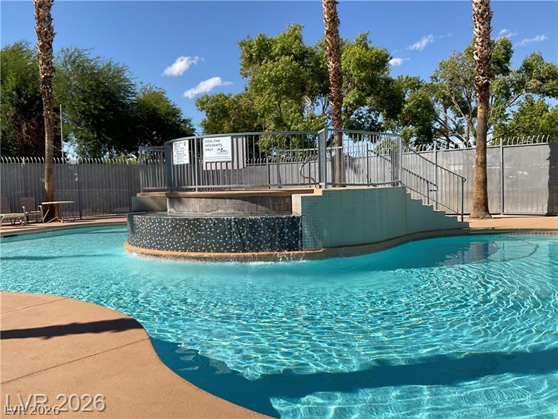 3318 North Decatur Boulevard, Unit 2152 Las Vegas, NV 89130 - Photo 38 of 58 Lush landscaping surrounds this crystal-clear community pool, perfect for tranquil relaxation.