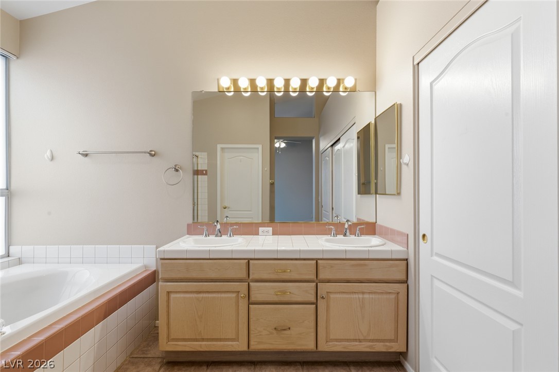 9034 Ridgepointe Way Henderson, NV 89074 - Photo 29 of 56 A spacious vanity with dual sinks sits adjacent to a deep soaking tub.