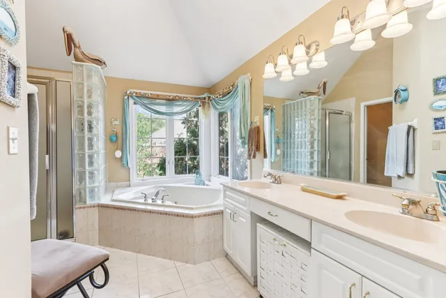 a bathroom with a large tub sink and large mirror