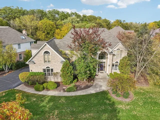 an aerial view of a house with a yard and trees
