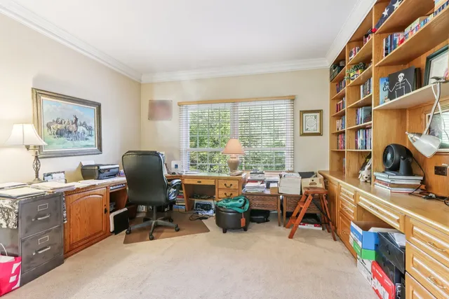 a view of a workspace with furniture and a window