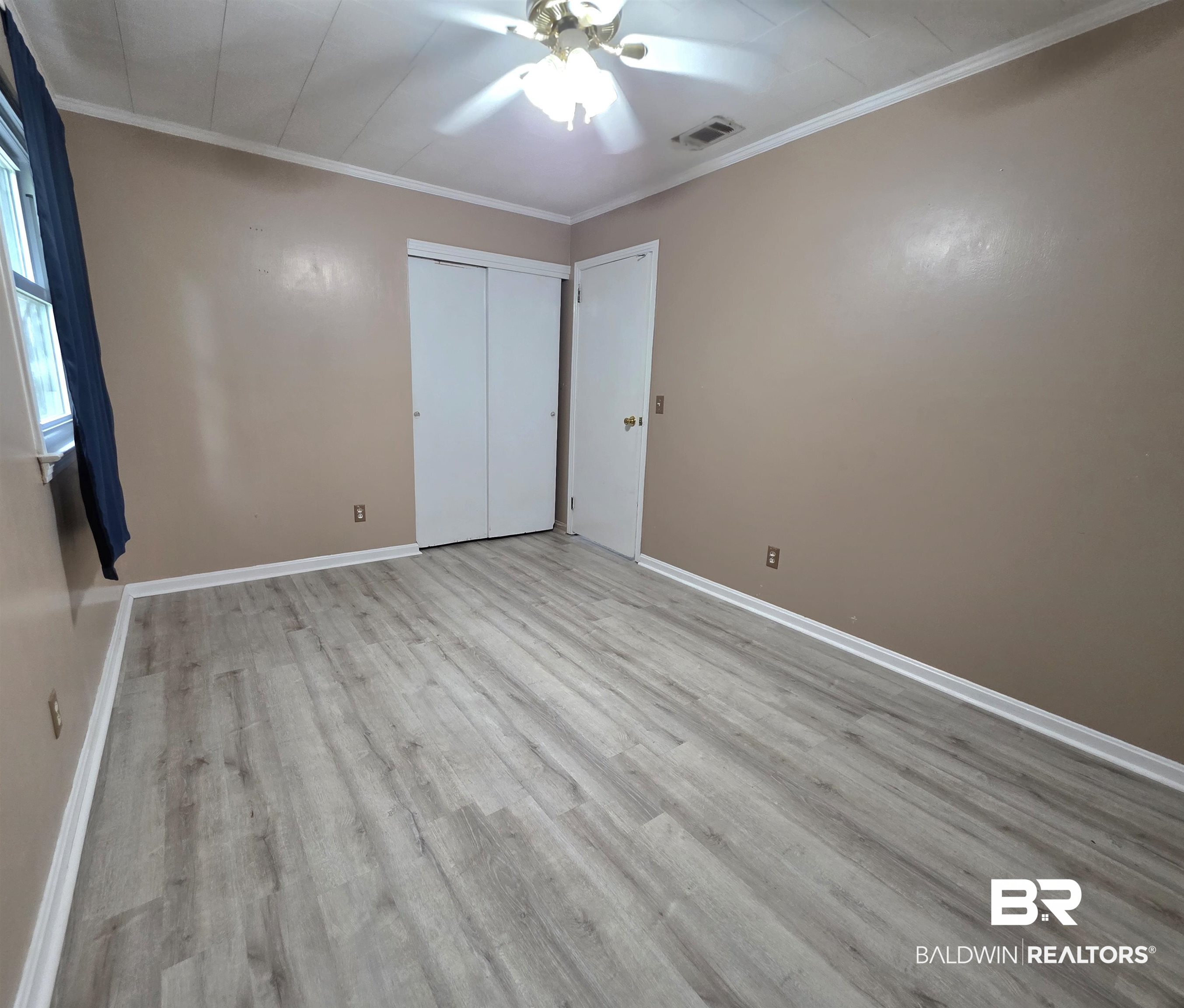 558 Stanton Road Atmore, AL 36502 - Photo 17 of 29 Spacious interior room featuring light-toned wood-finish flooring, neutral wall paint, and white trim