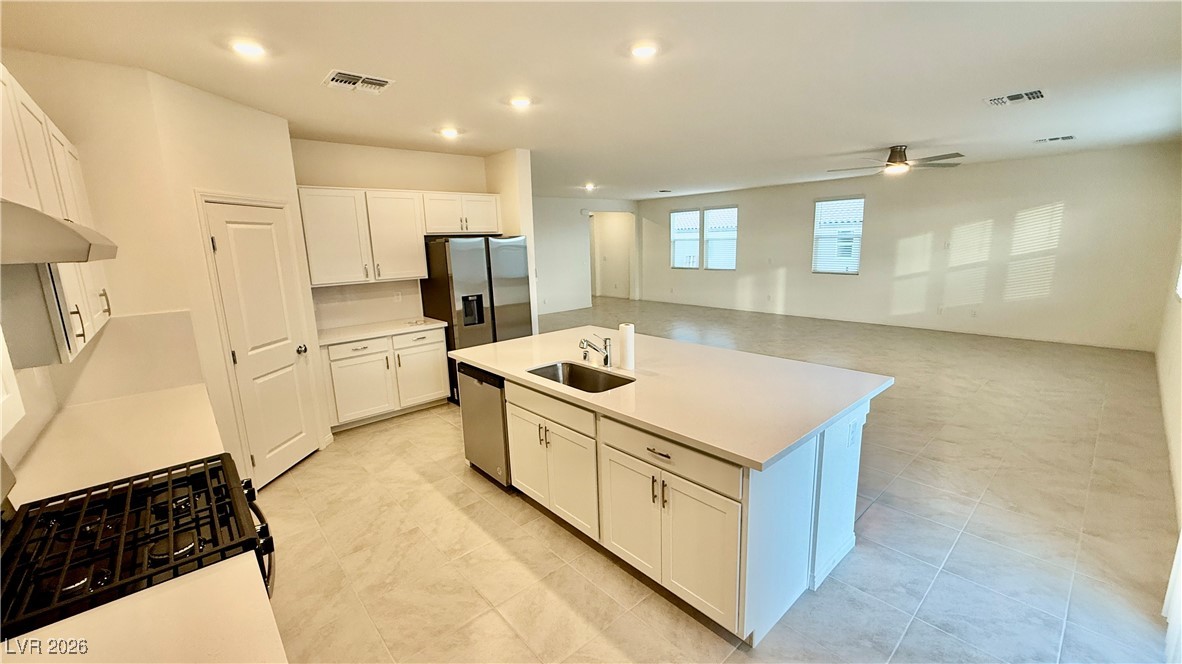 3119 Magnolia Rnch Avenue Las Vegas, NV 89139 - Photo 16 of 17 Kitchen with appliances with stainless steel finishes, white cabinets, a kitchen island with sink, open floor plan, and recessed lighting