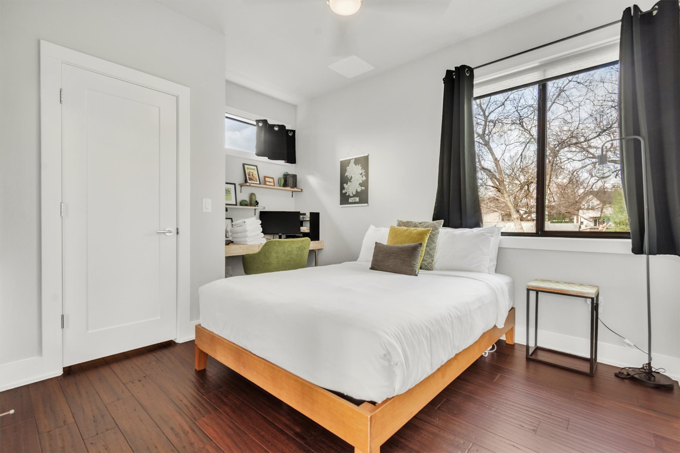 2706 Zaragosa Street, Unit 2 Austin, TX 78702 - Photo 14 of 25 A spacious secondary bedroom with dark hardwood floors and a large window framing the treetops.