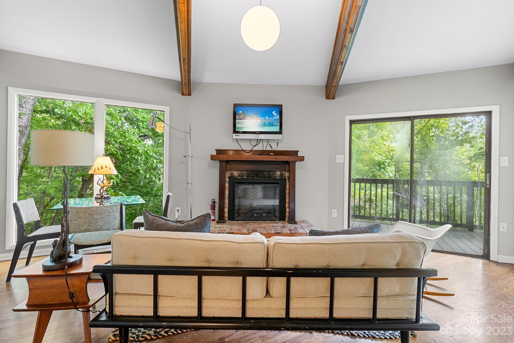 98 Westminster Road Montreat, NC 28711 - Photo 17 of 37 a living room with a balcony a fireplace and a floor to ceiling window