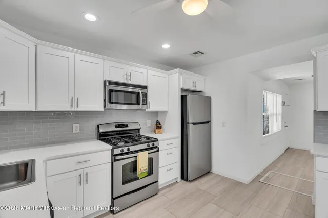 a kitchen with granite countertop a refrigerator stove and microwave