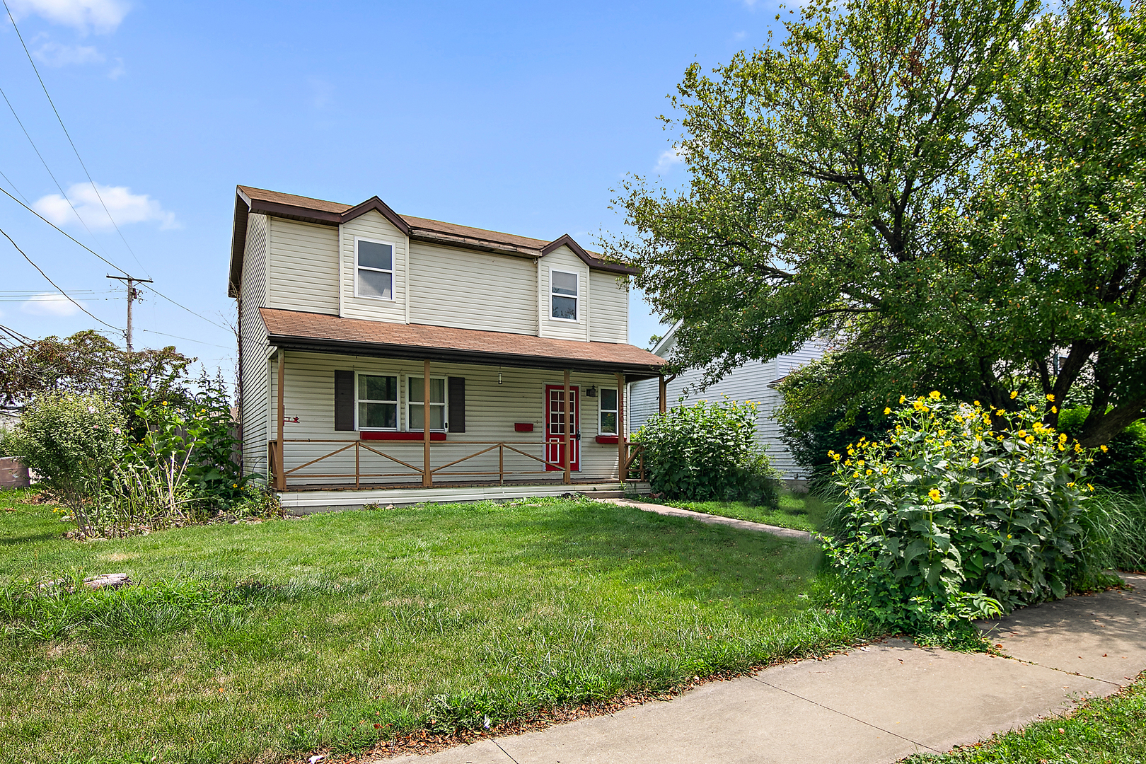 a view of house with a yard and sitting area