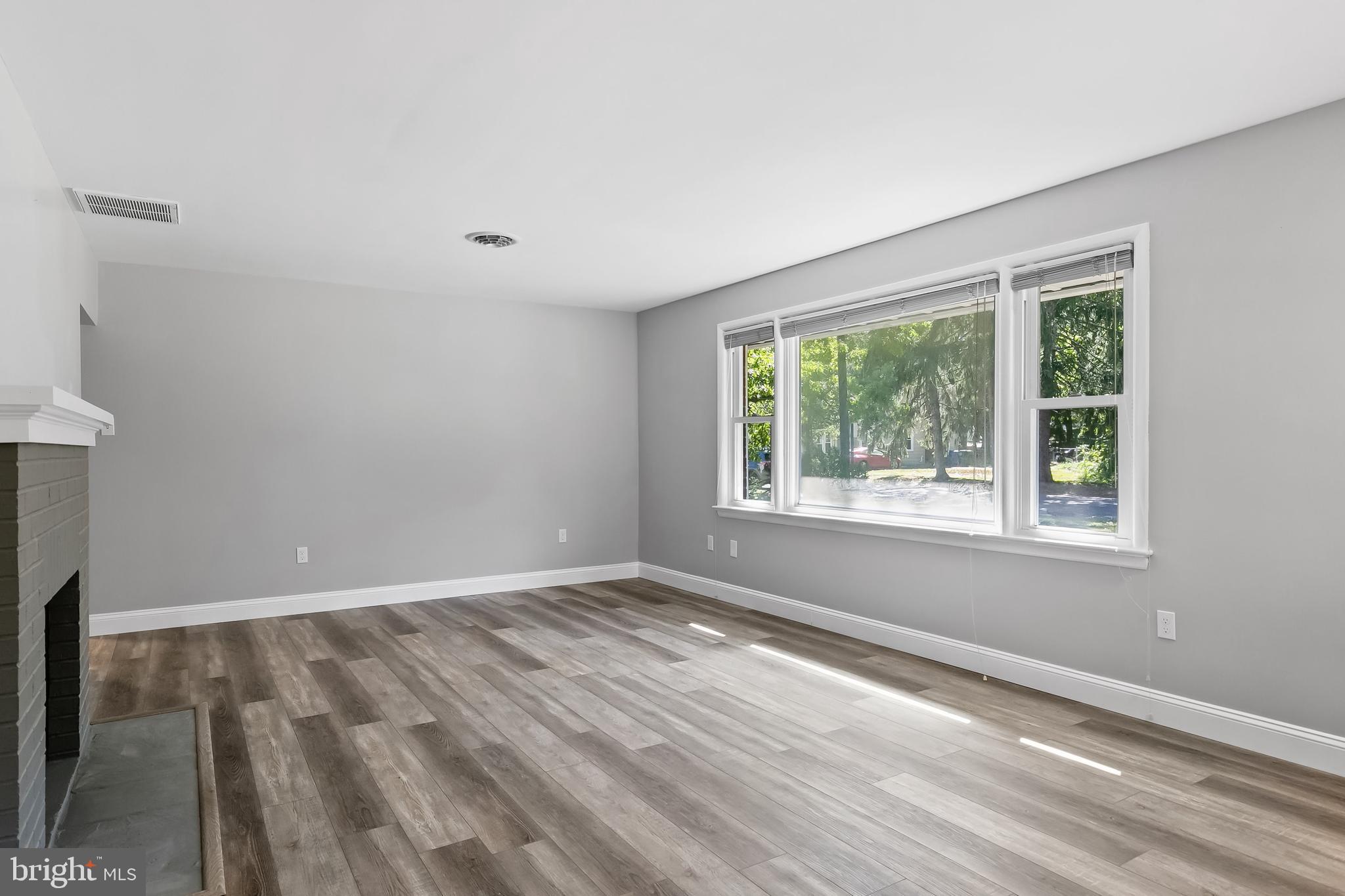 405 Hamilton Road Glassboro, NJ 08028 - Photo 5 of 28 a view of an empty room with wooden floor and a window