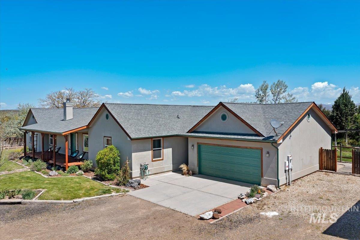 147 East Indian Crk Road Boise, ID 83716 - Photo 2 of 43 Ranch-style residence featuring a stucco exterior, a gray shingle roof, and a prominent attached garage with a turquoise door