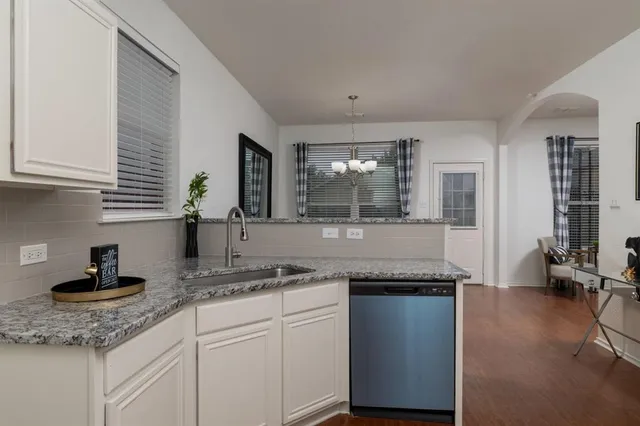 a kitchen with granite countertop kitchen island a sink appliances and cabinets