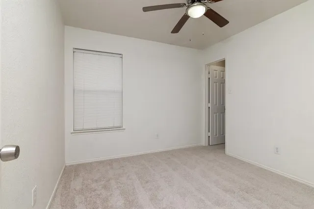 an empty room with chandelier fan