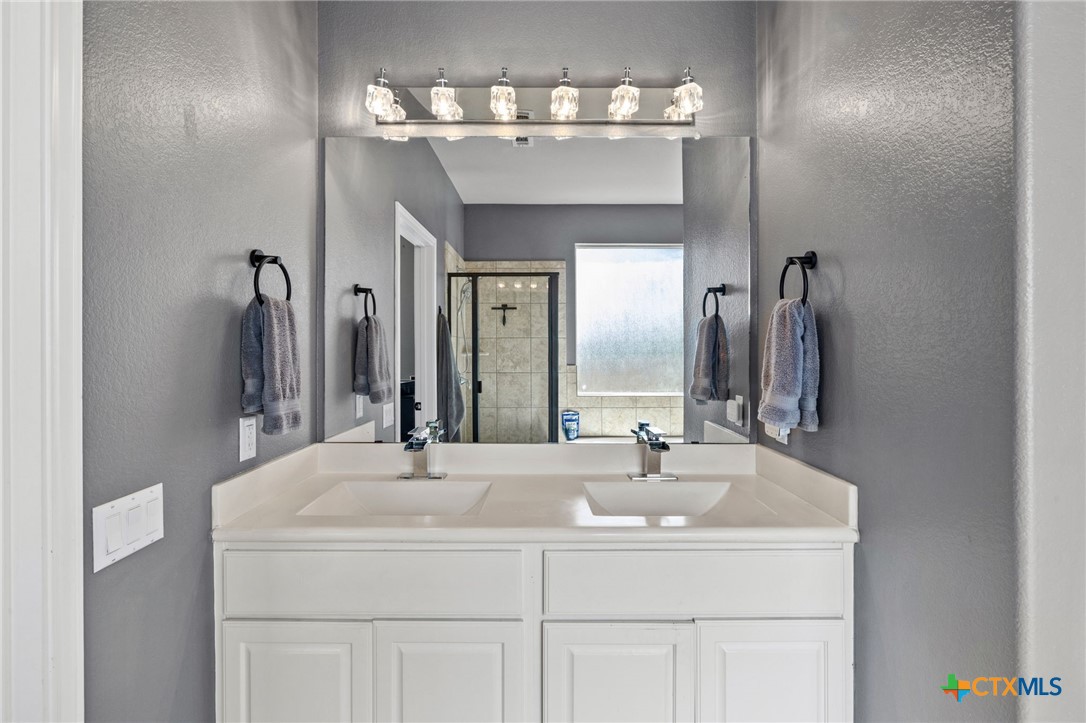 10113 Copper Ridge Cove Austin, TX 78747 - Photo 26 of 32 a bathroom with a sink and a mirror