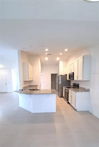 a kitchen with stainless steel appliances kitchen island granite countertop a sink and cabinets