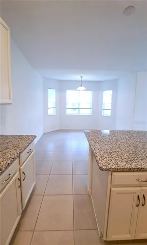 a kitchen with granite countertop white cabinets and white appliances