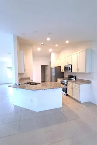 a large kitchen with a large counter top appliances and cabinets