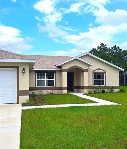 a view of a yard in front of a house with a large tree