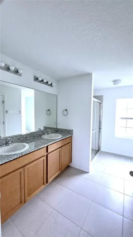 a spacious bathroom with a granite countertop sink and a mirror