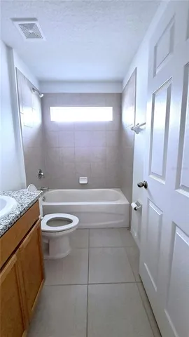 a spacious bathroom with a granite countertop toilet a sink and bathtub