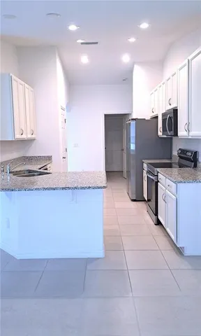 a kitchen with stainless steel appliances granite countertop a stove a sink and a refrigerator