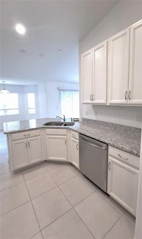 a kitchen with granite countertop white cabinets white stainless steel appliances with a sink and dishwasher