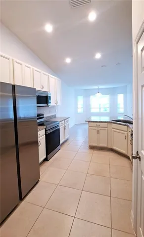 a large kitchen with a stove a refrigerator and a sink