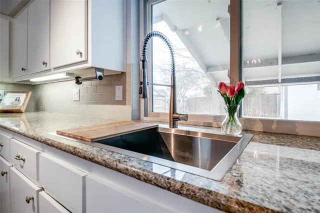a kitchen with granite countertop a sink and a window