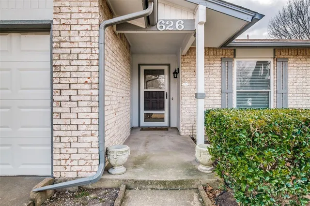 a view of a brick house with potted plants