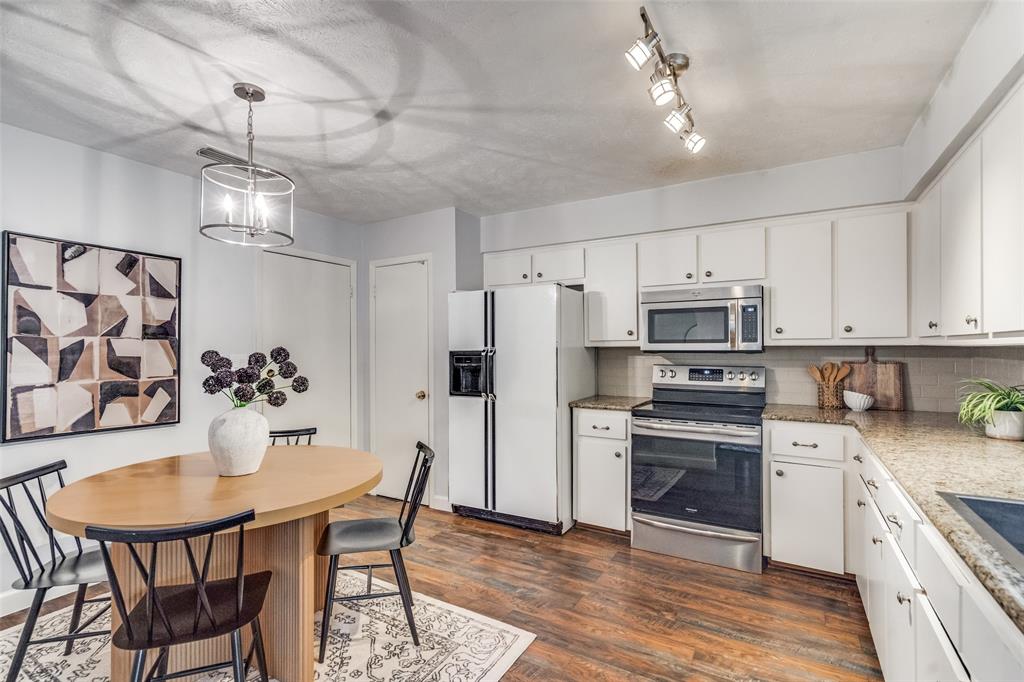 626 Shadyglen Drive Allen, TX 75002 - Photo 7 of 20 a kitchen with stainless steel appliances a dining table chairs stove refrigerator and microwave