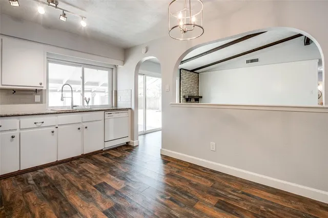 a view of a kitchen with wooden floor and electronic appliances