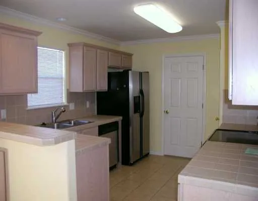 a kitchen with granite countertop a refrigerator and a sink