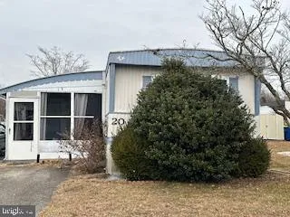 a view of a house with a plants and large tree