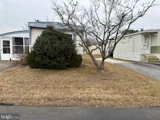 a view of a house with a large tree and wooden fence
