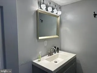 a bathroom with a sink mirror and vanity