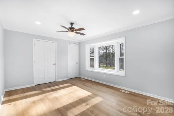 a view of empty room with wooden floor