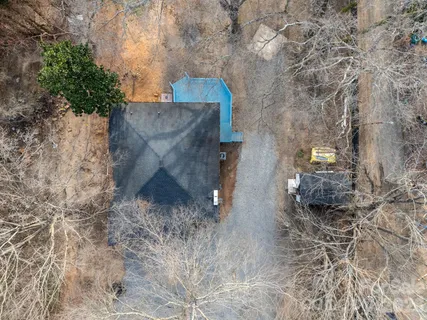 a view of a house with a yard and large trees