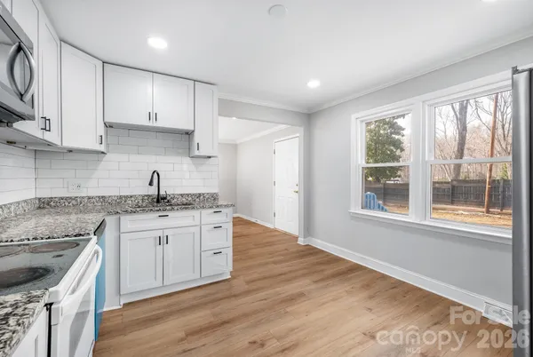 a kitchen with granite countertop a sink and a stove top oven