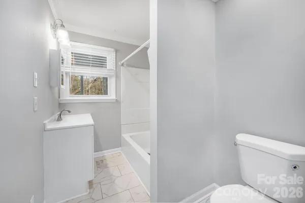 a bathroom with a toilet sink and window