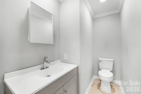a bathroom with a toilet sink vanity and mirror