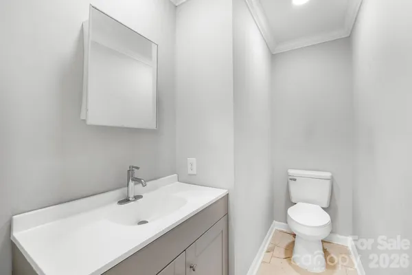 a bathroom with a toilet sink vanity and mirror