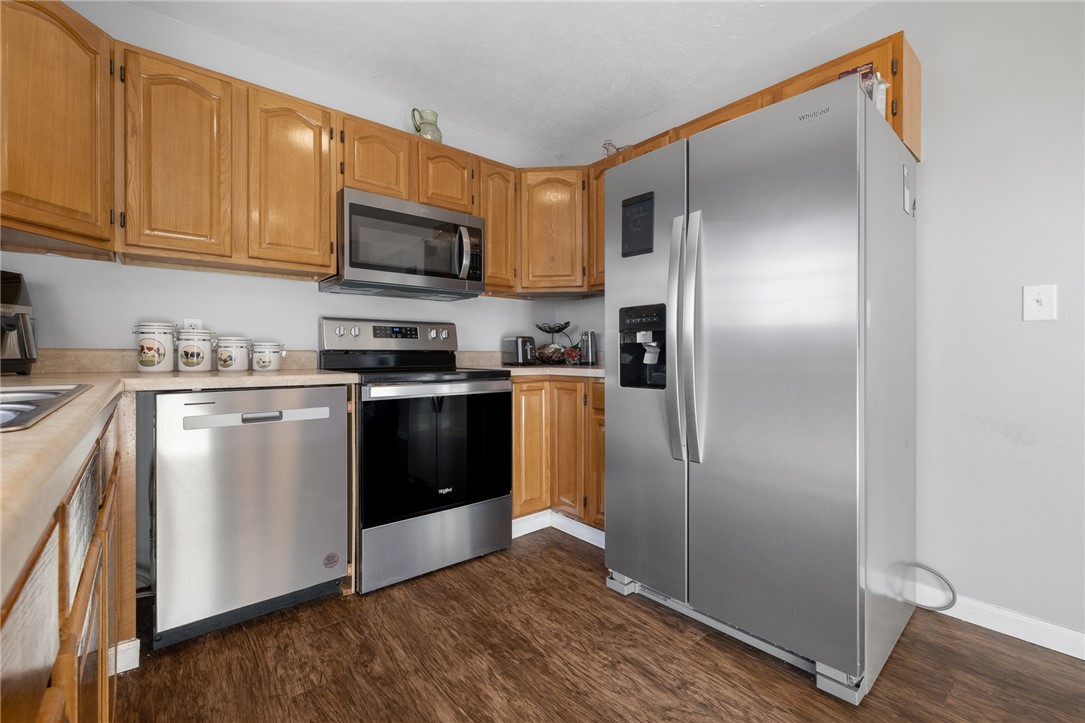 10974 Ricks Drive Harrison, AR 72601 - Photo 22 of 59 Kitchen with stainless steel appliances, light countertops, dark wood-style flooring, and wood finish cabinetry