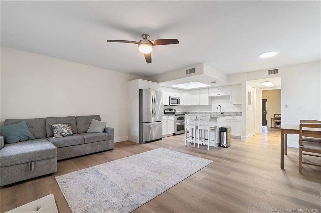 511 Southwest South River Drive, Unit 104 Stuart, FL 34997 - Photo 13 of 61 a living room with furniture and kitchen view