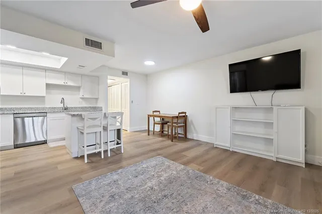 a kitchen with stainless steel appliances a refrigerator a stove a sink a dining table and chairs